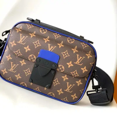Brown monogram canvas crossbody bag with blue trim and a wide black shoulder strap