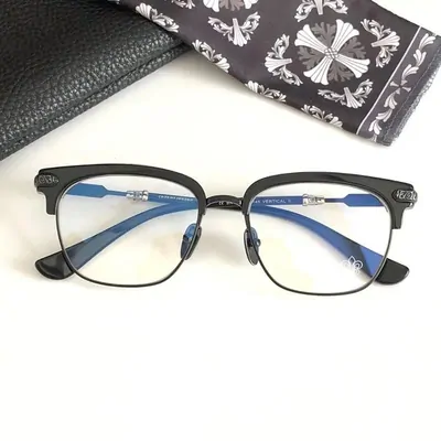 Black half-rim glasses with blue tinted lenses, lying on a patterned cloth