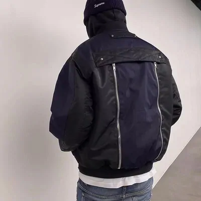Navy and black bomber jacket worn from behind, a zip running across the back panel, with a beanie