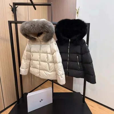 Cream and black fur-hood puffer coats hanging side by side on a clothes rail
